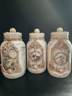 three jars with pictures on them sitting on a table