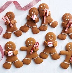 several gingerbreads with candy canes and candies on them are arranged in the shape of people