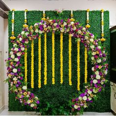 an arrangement of flowers and greenery on the wall