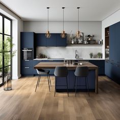 a modern kitchen with blue cabinets and wooden flooring, an island table surrounded by chairs