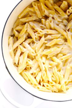 a pot filled with macaroni and cheese on top of a stove