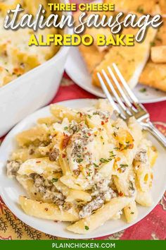 a plate with pasta and cheese on it next to some breadsticks in the background