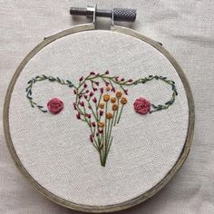 a close up of a embroidery on a piece of cloth with flowers in the middle