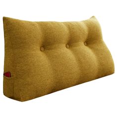 an upholstered headboard with buttons on the bottom and sides, in mustard colored fabric