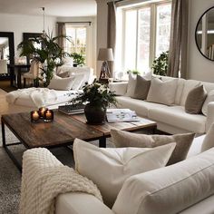 a living room filled with white furniture and lots of windows