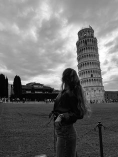 a woman standing in front of the leaning tower