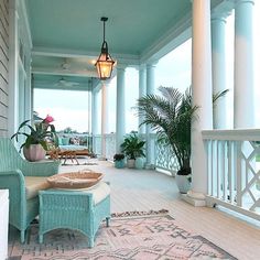 a porch with wicker furniture and potted plants