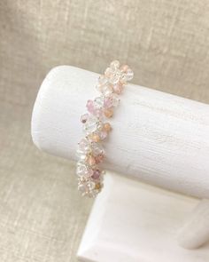 This piece is a soft, feminine bouquet for your arm. In this lovely piece, I have clustered together a beautiful collection of tiny gemstones. Topaz rondelles, in various shades of pink, are accented with sparkling crystal quartz, luminous tiny seed pearls, and subdued peach moonstone. The soft shades of pink are neutral in tone, making this a versatile piece that can be worn with a variety of outfits. Each petite gemstone and pearl is individually wire-wrapped in sterling silver, a process that Adjustable Crystal Bracelet With Stones For Wedding, Adjustable Crystal Stone Bracelet For Weddings, Crystal Gemstone Bracelets For Wedding, Adjustable Natural Stone Beaded Bracelets For Wedding, Wedding Beaded Bracelet With Gemstone Beads, Delicate Beaded Crystal Bracelet, Delicate Gemstone Bracelets For Wedding, Dainty Pink Beaded Bracelets For Wedding, Adjustable Gemstone Beads Bracelet For Wedding