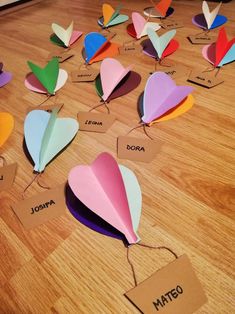 colorful paper hearts are arranged on the floor with name tags attached to them and labeled in spanish