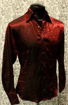 "A classic cut men's shirt with flash! Comfortable, light-weight dark red shimmer fabric adds a lot of style to a traditional cut. A generous, slimming fit fastened with rich black pearl snaps down front and at cuffs. Definitely will make you stand out in a crowd. Comes in sizes small-XXL. These shirts are large and drapey. Order a size smaller than what you usually wear. Check the measurements below. Measurements: Small: Chest 46\" Waist 42\" Medium: Chest 49\" Waist 44\" Large: Chest 52\" Wais Fitted Red Shirt For Party, Fitted Burgundy Shirt For Fall, Red Button-up Party Tops, Red Formal Shirt For Summer, Formal Red Summer Shirt, Red Collared Party Shirt, Red Collared Shirt For Party, Red Party Shirt For Fall, Classic Red Top For Party