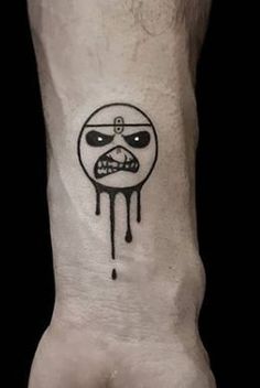 a person's hand with a tattoo on it that has a face drawn in the middle