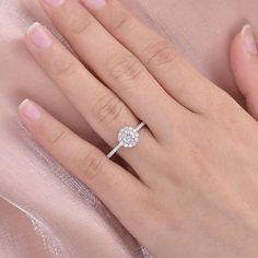 a woman's hand with a diamond ring on top of her wedding dress,