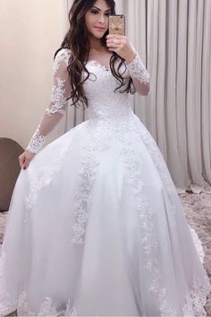 a woman is taking a selfie in her wedding dress while holding a cell phone