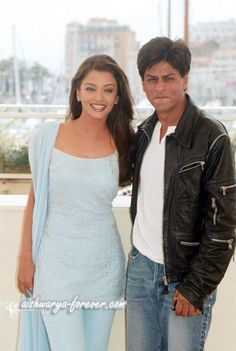 a man and woman standing next to each other in front of a cityscape