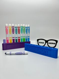 the glasses are next to some markers and pens