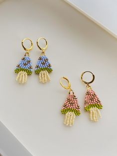 three pairs of beaded earrings on top of a table