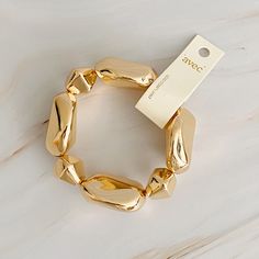 Introducing our Golden Pebble Stretch Bracelet - a sleek, geometric design that effortlessly combines edge and minimalism. Crafted with cool-toned pebbles, this bracelet will add a touch of modern sophistication to any outfit. Stretch design ensures a comfortable fit. Dimensions: approximately 8" before stretch Gold plated alloy metal Lead and Nickel compliant Made in China Scrunchie Hairstyles, Steel Jewelry, Stainless Steel Jewelry, Hair Accessories Headbands, Vintage Shoes, Clothes Gift, Touch Of Modern, Ring Bracelet, Stretch Bracelets