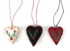 three heart ornaments hanging from red string