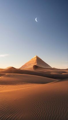 the desert with sand dunes and a pyramid in the distance