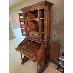 an old wooden desk and chair in a room with carpeted flooring on the ground