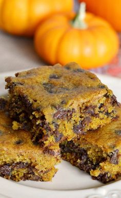 two pieces of chocolate chip cake sitting on top of a white plate next to an orange