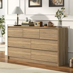 a large wooden dresser sitting in a living room next to a wall with pictures on it