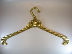 an ornate gold coat hanger on a white wall