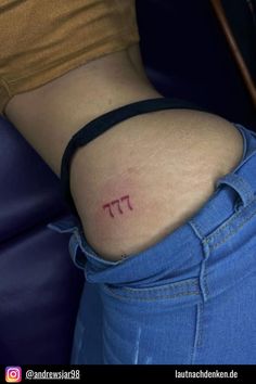 a woman's lower back tattoo with the word pi on it in red ink