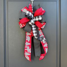 a red and black bow hanging on the front door with polka dots, bows and crosses