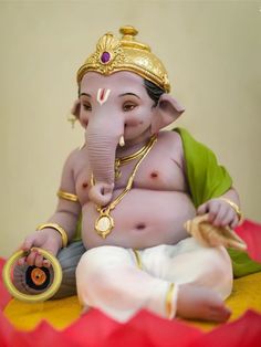 an elephant statue sitting on top of a red and yellow table cloth covered floor next to a wall