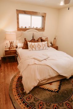 a large bed sitting on top of a wooden floor next to a window in a bedroom