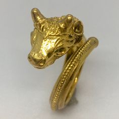 Antique 22K GOLD El Toro Head Ring 7.7 Gram Size 5 Adjustable Granulation Hand Made This antique 22k gold bull head ring is a stunning piece of jewelry that will add a touch of elegance to any outfit. The ring is handcrafted with intricate engravings and is adjustable to fit a size 5 finger. The ring weighs 7.7 grams and is made in the United States. The ring features a beautiful gold color and is designed with a bull head theme, making it a perfect gift for any animal lover. The vintage piece has no stones and is unisex, making it suitable for anyone to wear. This ring is a unique and original piece of jewelry that will make a statement in any collection. Bull Head, Head Ring, Wedding Gift Baskets, 7 And 7, 22k Gold, Early 20th Century, Hallmark, Favorite Jewelry, Statement Rings