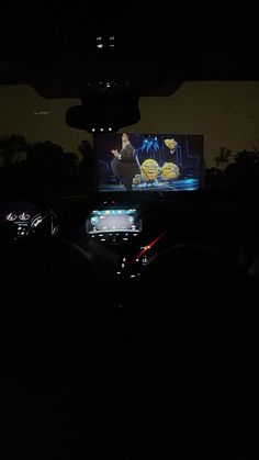 the interior of a car is lit up at night with an image of batman on the screen