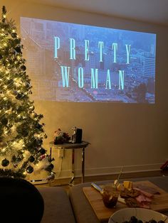 a living room with a christmas tree in front of a projector screen that says pretty woman