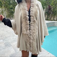 Throw On Shawl/Poncho Super Chic Faux Fur Detailing One Size Chic Winter Shawl Poncho, Chic One Size Cape Poncho, Chic One-size Cape Poncho, Chic One Size Poncho For Winter, Chic Winter Shawl Cape, Chic One-size Shawl Cape, Elegant One-size Beige Outerwear, Fall Poncho With Faux Fur Trim Cape, Chic Shawl Outerwear One Size