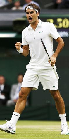 a man holding a tennis racquet on top of a tennis court in front of a crowd