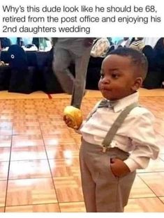 a little boy standing on top of a hard wood floor holding an apple in his hand