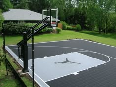 an outdoor basketball court surrounded by grass and trees