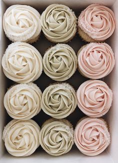 cupcakes in a box with frosting swirls on the top and bottom