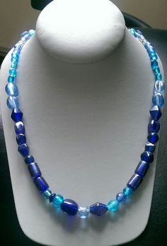 This one-of-a-kind beaded necklace is made with assort blue glass beads. Toggle clasp. Measures 23" long end to end. Blue Oval Faceted Bead Jewelry, Blue Single Strand Necklace With Oval Beads, Blue Necklaces With Adjustable Oval Beads, Blue Oval Beaded Beads, Handmade Blue Beaded Necklaces With Oval Beads, Blue Beaded Czech Glass Necklaces, Handmade Blue Beaded Necklace With Oval Beads, Handmade Blue Oval Beads Jewelry, Handmade Blue Oval Bead Jewelry