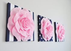 three canvases with pink flowers and polka dots on them are hanging on the wall