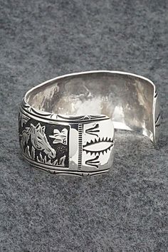 This expertly crafted sterling silver bracelet featuring horses was made by Navajo silversmith Richard Singer. The back is signed R Singer and stamped .925.Size: 5 5/8" (will fit up to a 6 3/4" wrist)Gap: 1 1/8"Width: 1"Free shipping on all orders! We ship with USPS and always include tracking. All orders ship within a day of payment.Returns are accepted up to 30 days after you receive your order. Just send us a message. Our shop offers cash back or store credit. The item must be returned in new Southwestern Silver Cuff Bracelet With Inlay, Western Sterling Silver Cuff Bracelet Gift, Western Sterling Silver Cuff Bracelet, Adjustable Sterling Silver Western Cuff Bracelet, Unique Stamped Sterling Silver Collectible Bracelet, Adjustable Western Sterling Silver Cuff Bracelet, Western Sterling Silver Bracelets, Western Style Sterling Silver Bangle, Western Style Sterling Silver Cuff Bracelet