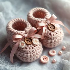 two crocheted baby shoes with buttons on them