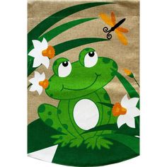 a green frog with white flowers and a dragon on it's back is sitting in the grass