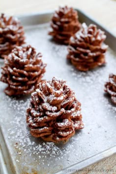 several pine cones covered in powdered sugar on a baking sheet