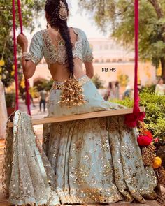 a woman is sitting on a swing with her back to the camera and looking down