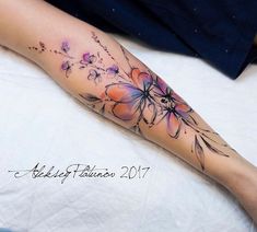 a woman's leg with flowers on it and the bottom half of her arm