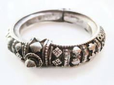 A beautiful Indian petite silver bracelet with lovely applique decoration on almost all of the body of the bracelet. It is hinged and closes with a central screw clasp. The patina on this high-grade silver bracelet is lovely and in good condition for its age. It is meant for quite a small wrist. The hinge is wobbly. Inner circumference is 13.5 cm (5 3/8"). Inner diameter is 4.7 cm (1 7/8"). Width is 1 cm (just under 1/2"). Weight is 59.5 grams. For more Indian jewelry: https://www.etsy.com/shop/ Silver Hinged Bangle As Gift, Silver Hinged Bangle For Anniversary, Anniversary Silver Hinged Bangle, Classic Silver Ceremonial Bangle, Silver Hinged Bangle For Wedding, Silver Hinged Bracelets For Weddings, Hinged Sterling Silver Bangle In Silver, Silver Hinged Bracelet For Wedding, Antique Silver Bracelets With Clasp