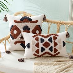 two decorative pillows on a wicker chair