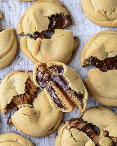 peanut butter chocolate chip cookies on a baking sheet with one cut in half and the other partially eaten